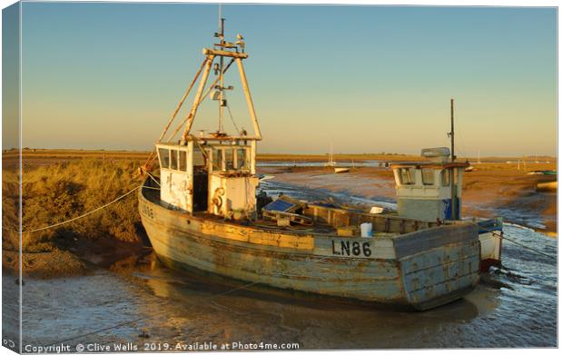 Fishing boat grounded at Brancaster Staith Canvas Print by Clive Wells