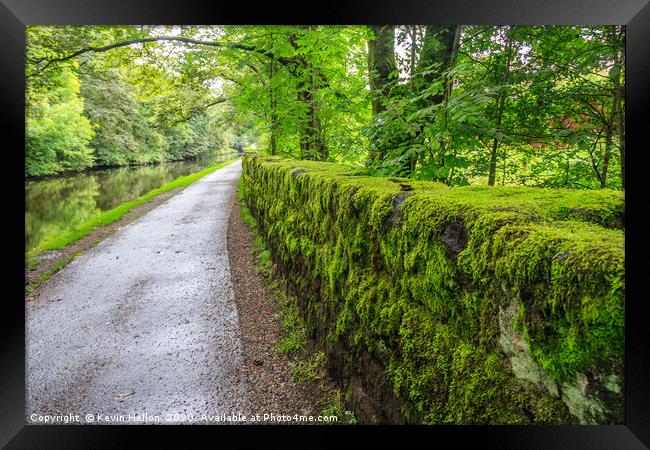 Towpath and green moss growing on stone wall Framed Print by Kevin Hellon