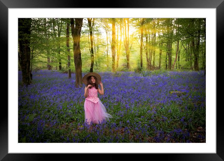 Small girl walks through bluebell woods in pink dress Framed Mounted Print by Alan Hill