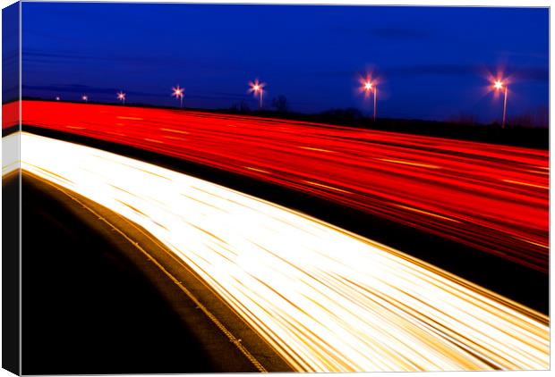 Light trails caused by multiple car headlights and tail lights Canvas Print by Alan Hill