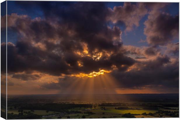 Crepuscular rays of sunlight shine onto fields in Dorset Canvas Print by Alan Hill