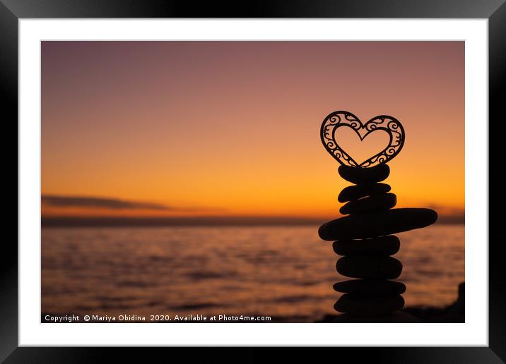 Heart on stones on the beach at sunset. Framed Mounted Print by Mariya Obidina