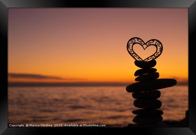 Heart on stones on the beach at sunset. Framed Print by Mariya Obidina