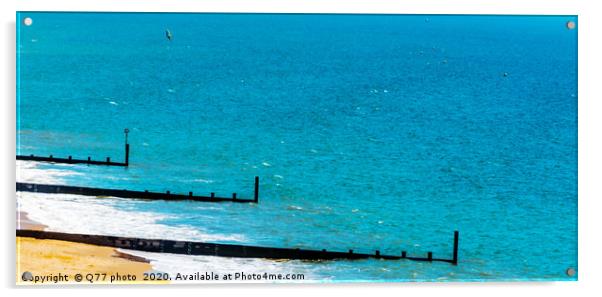 Dock pilings on a sandy beach, blue ocean and yell Acrylic by Q77 photo