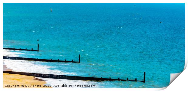 Dock pilings on a sandy beach, blue ocean and yell Print by Q77 photo
