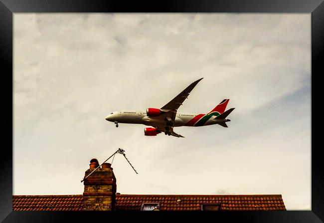 Passenger plane flying over the roofs of residenti Framed Print by Q77 photo