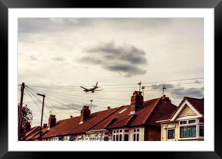 Passenger plane flying over the roofs of residenti Framed Mounted Print by Q77 photo