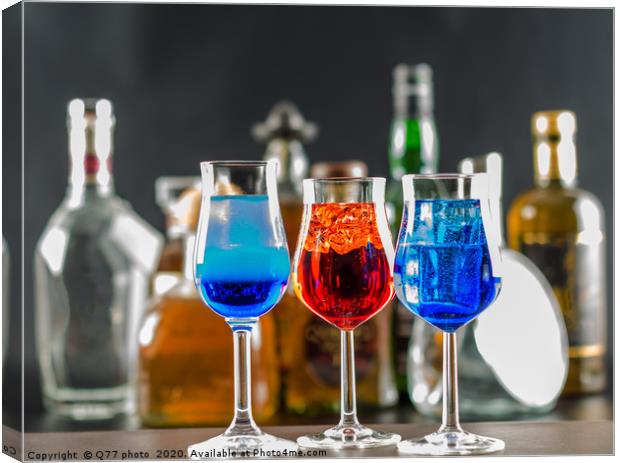 Colorful drink on the background of bottles in ori Canvas Print by Q77 photo