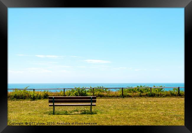 Empty bench on a hill on the ocean shore, green lu Framed Print by Q77 photo