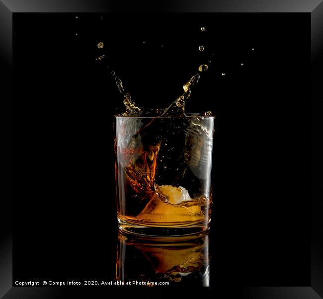 Splash in glass of whiskey and ice Framed Print by Chris Willemsen