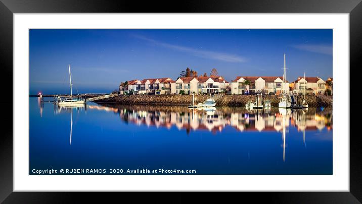 Sailboats moored on a peaceful harbor at night. Framed Mounted Print by RUBEN RAMOS