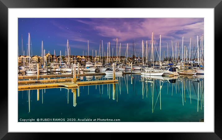 Sailboats moored on a peaceful bay at night. Framed Mounted Print by RUBEN RAMOS