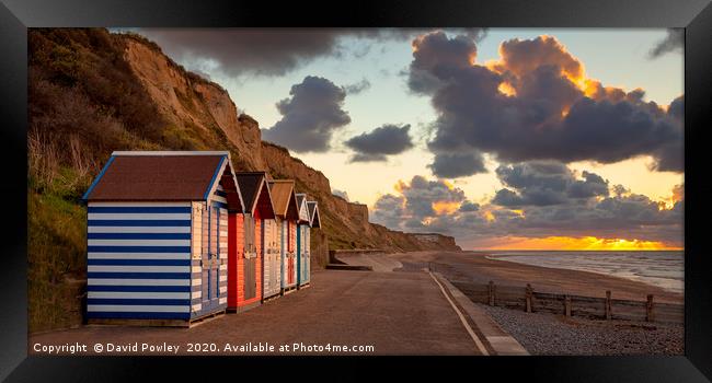 Cromer beach huts at sunset Framed Print by David Powley