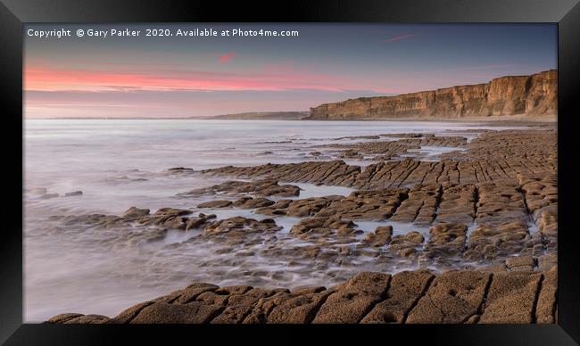 The ocean, washing over a rocky shore, at sunset Framed Print by Gary Parker