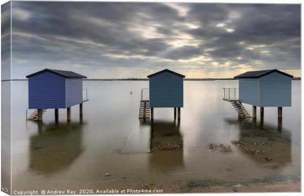 Shafts of light over Osea Beach Huts Canvas Print by Andrew Ray