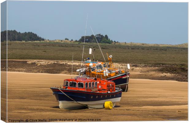 Lifeboats on the mud flats at Wells-Next-Sea Canvas Print by Clive Wells