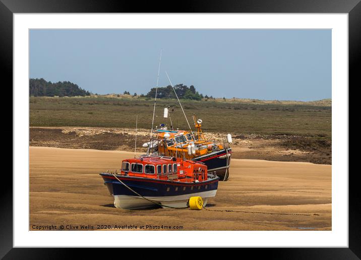 Lifeboats on the mud flats at Wells-Next-Sea Framed Mounted Print by Clive Wells