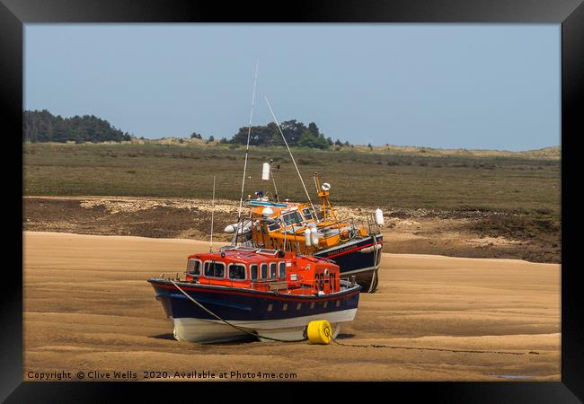 Lifeboats on the mud flats at Wells-Next-Sea Framed Print by Clive Wells