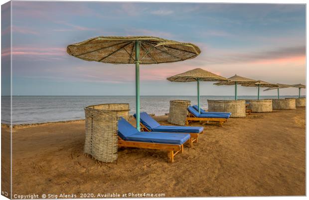 loungers and shelters in a row at the sunset on a  Canvas Print by Stig Alenäs