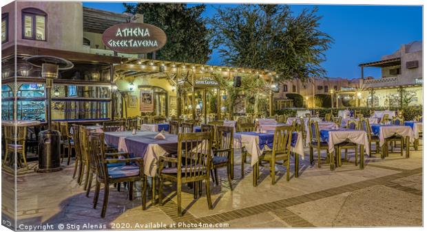 illuminated greek taverna with tables and chairs i Canvas Print by Stig Alenäs