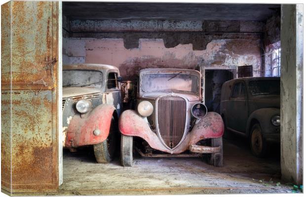 Abandoned Vintage Cars in Garage Canvas Print by Roman Robroek