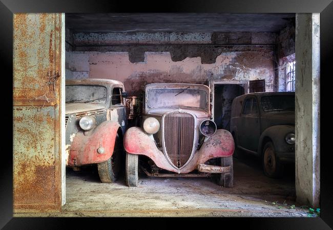 Abandoned Vintage Cars in Garage Framed Print by Roman Robroek