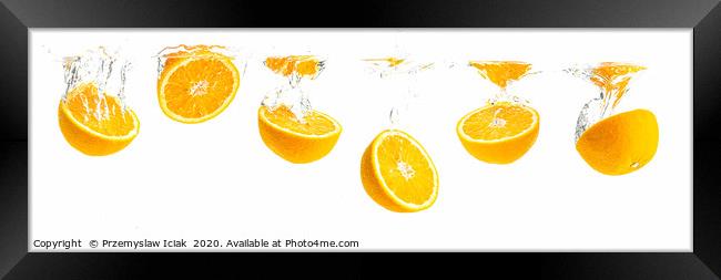 Orange halves splashing into water panorama shoot Framed Print by Przemek Iciak