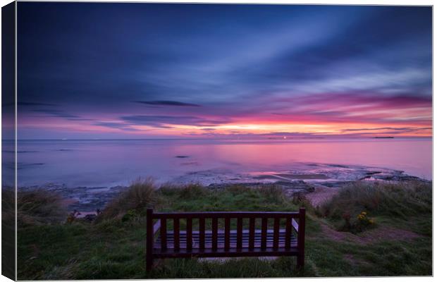 Bamburgh beach with a lone bench Canvas Print by John Finney
