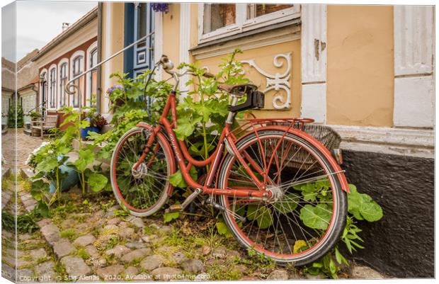 a red retro bike leaning up against a wall with ho Canvas Print by Stig Alenäs