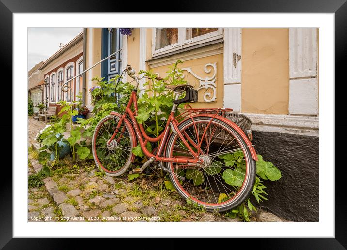 a red retro bike leaning up against a wall with ho Framed Mounted Print by Stig Alenäs