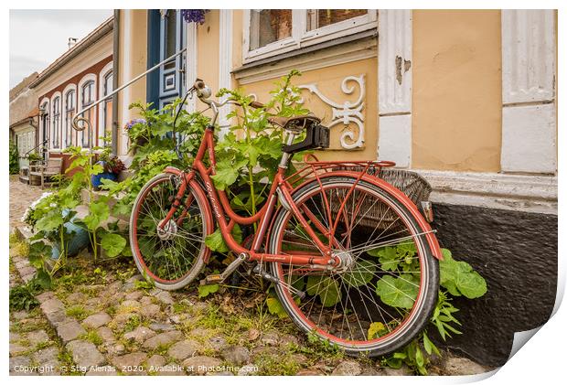a red retro bike leaning up against a wall with ho Print by Stig Alenäs