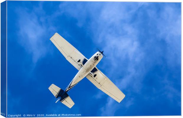 Small Aeroplane with blue sky and light clouds Canvas Print by Miro V