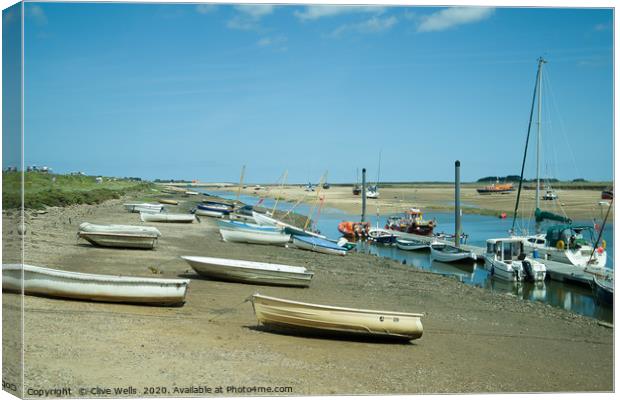 Rowing boats at low tide seen at Wells-Next-Sea in Canvas Print by Clive Wells
