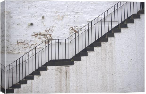 Black stairs on white wall Canvas Print by Theo Spanellis