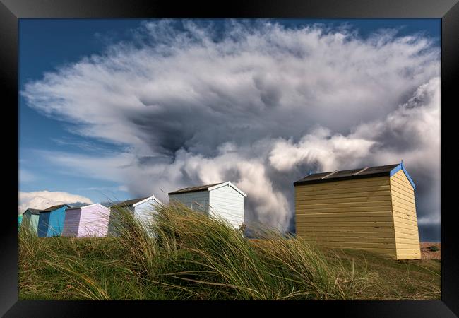 Kent Beach Huts with storm clouds Framed Print by John Finney