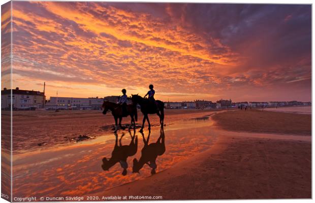 Fiery  sunset on weymouth beach horses Canvas Print by Duncan Savidge