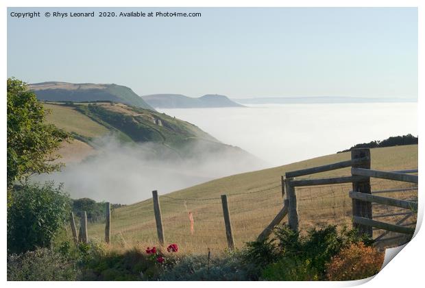 Sea mist rises from under green cliffs Print by Rhys Leonard
