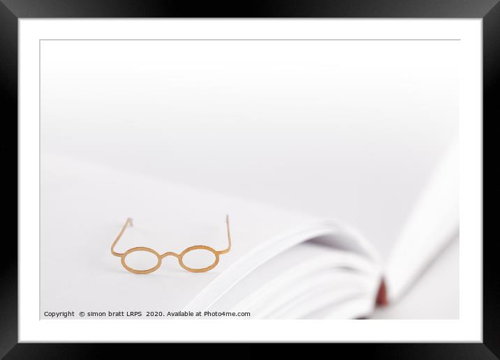Tiny reading glasses on open book Framed Mounted Print by Simon Bratt LRPS
