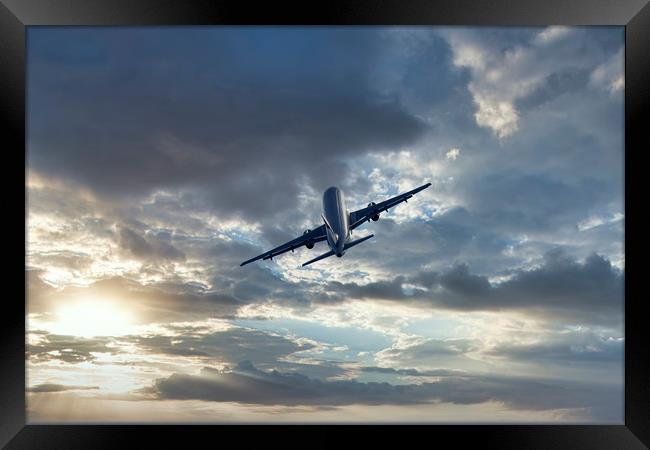 Passenger airplane on a cloudy sky Framed Print by Arpad Radoczy