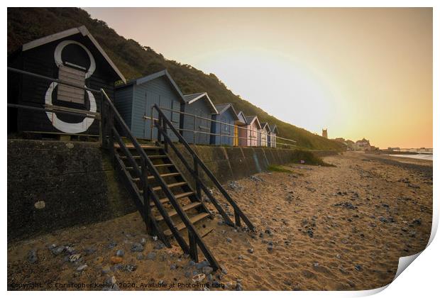 Sunset over Cromer beach huts Print by Christopher Keeley