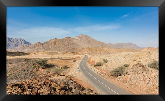 A road going thru the deserted mountains of Oman Framed Print by David GABIS