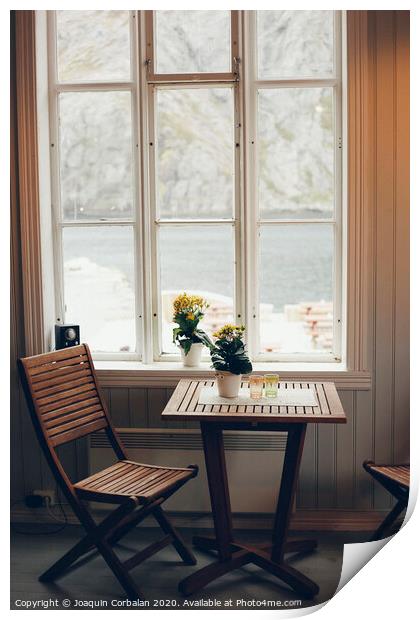 Empty table and antique wooden chairs near a window Print by Joaquin Corbalan