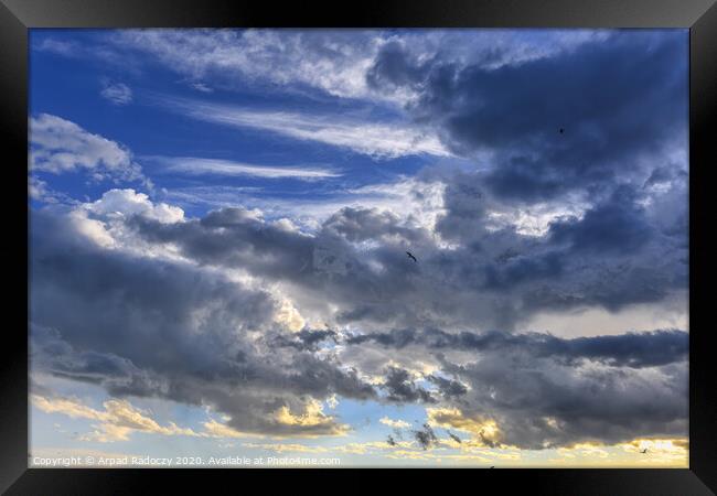 Nice clouds after a storm with sunset light Framed Print by Arpad Radoczy