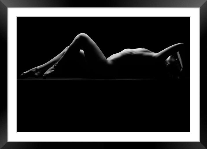 a woman nude and naked in fine art photography bodyscape laying on black studio background Framed Mounted Print by Alessandro Della Torre
