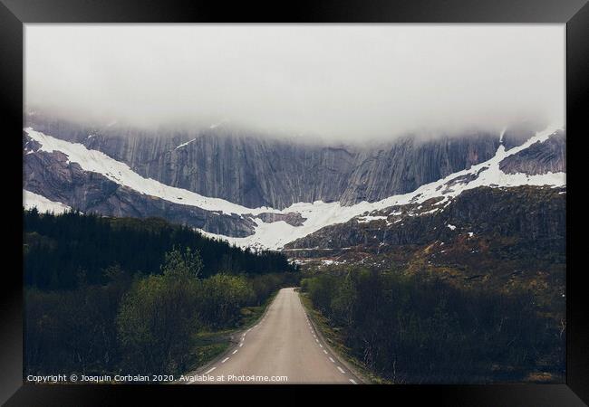 Challenging road to a rocky mountain with fog Framed Print by Joaquin Corbalan