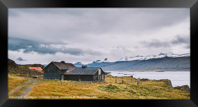 Village with farms in a rural area of the mountains of Iceland, with snowy mountains in the background. Framed Print by Joaquin Corbalan