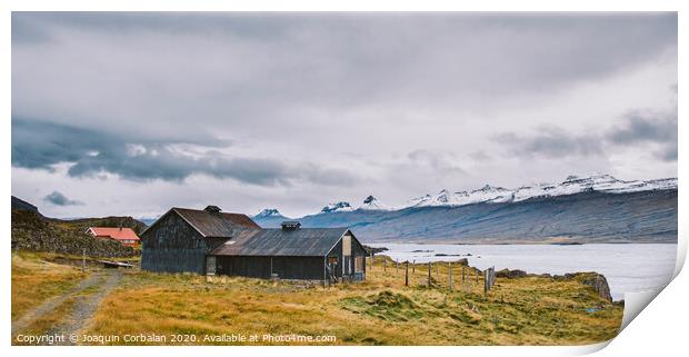 Village with farms in a rural area of the mountains of Iceland, with snowy mountains in the background. Print by Joaquin Corbalan