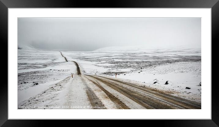 Road covered in snow one winter stormy day, very dangerous to drive due to adverse weather. Framed Mounted Print by Joaquin Corbalan