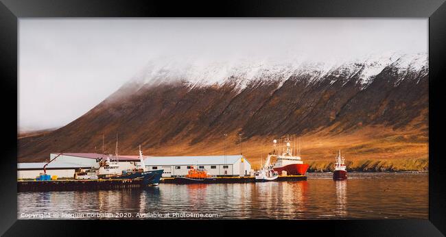 Fishing port of the village of Seydisfjordur, in Iceland, with vibrant colors and reflections in the sea of fishing boats. Framed Print by Joaquin Corbalan