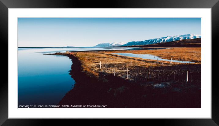 Relaxing landscape to calm down and relieve stress, blue lake with serene and calm waters in the middle of wild nature. Framed Mounted Print by Joaquin Corbalan